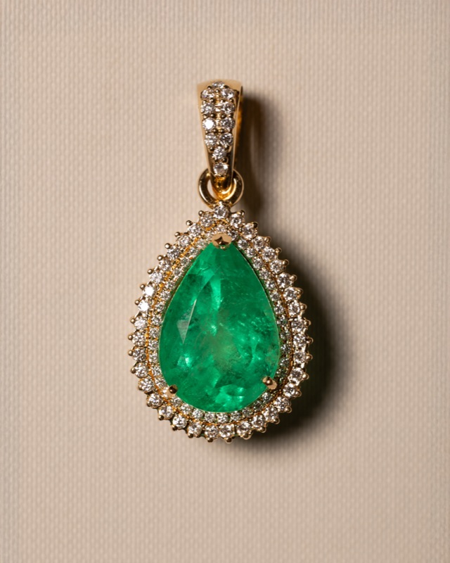 Pear-shaped emerald pendant with diamond halo in 18k gold