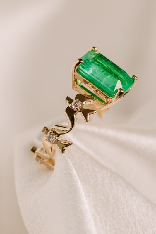 Ring in 18k gold with emerald-cut emerald and star-shaped diamond details