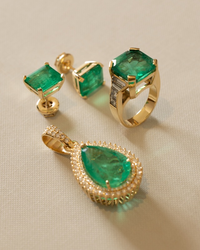 Bespoke jewelry set: earrings, ring, and pendant in 18k gold with emeralds