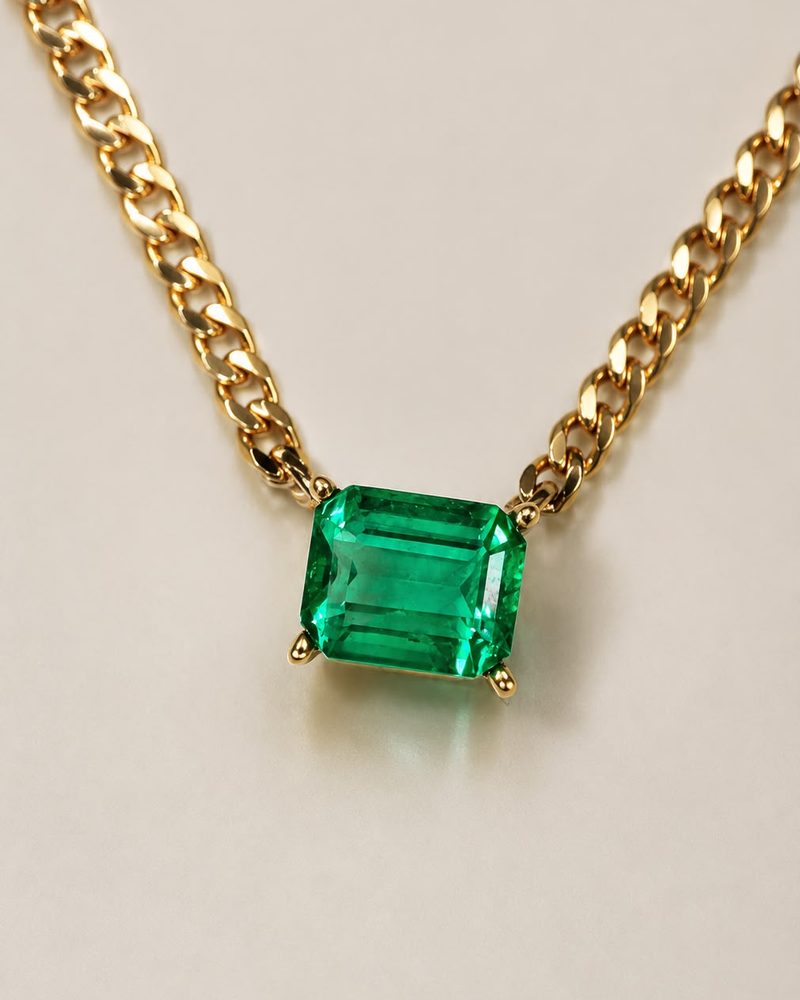 Emerald-cut emerald set on a curb chain necklace in 18k gold